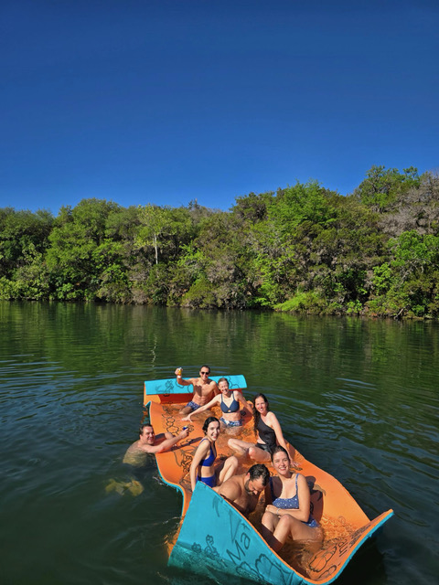 a group of people sitting in a boat on a body of water