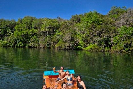a group of people sitting in a boat on a body of water
