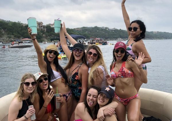 a group of people posing in front of a body of water
