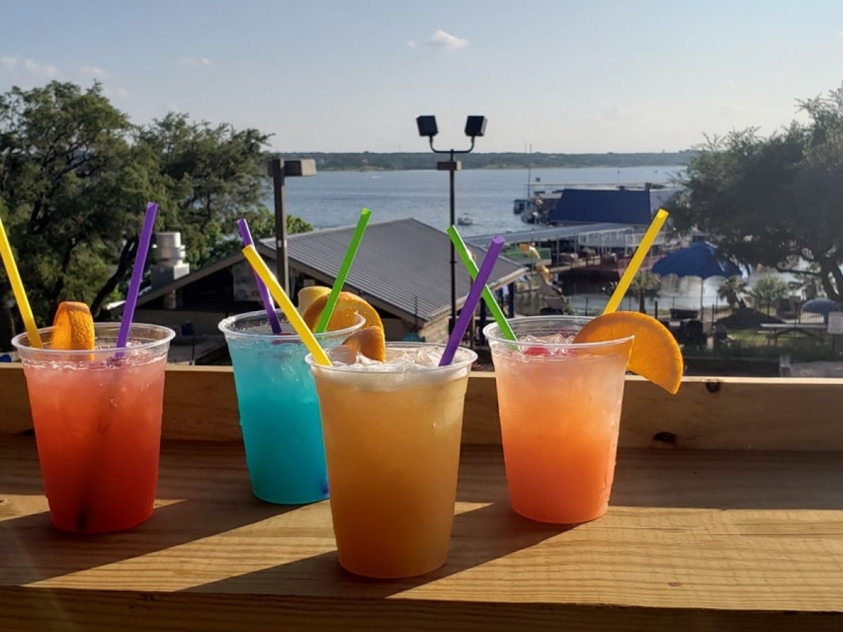 a glass of orange juice next to a picnic table