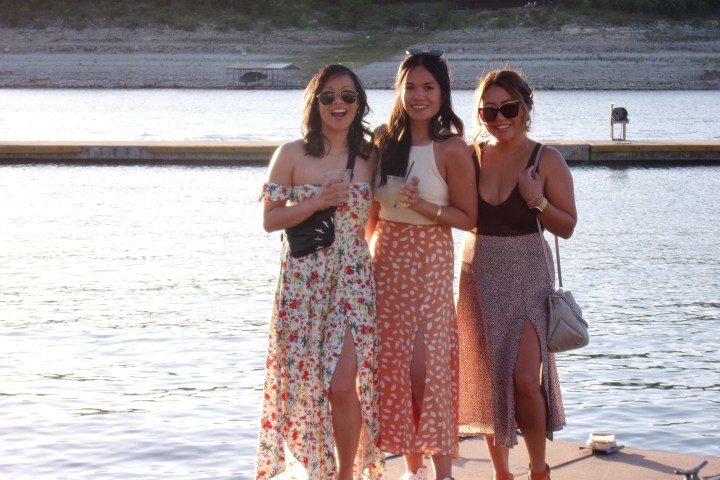a couple of women standing next to a body of water