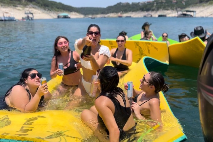 a group of people sitting on a raft in a body of water