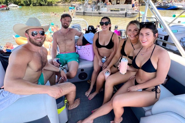 a group of people sitting on a boat posing for the camera