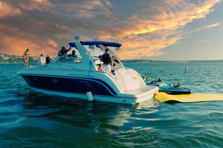 People on a boat in a lake under a dramatic sunset sky.